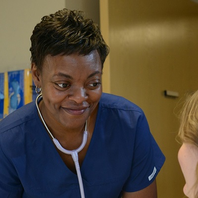 A black nurse working with a patient.